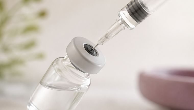 Frasco de medicamento e seringa preparados para aplicação
